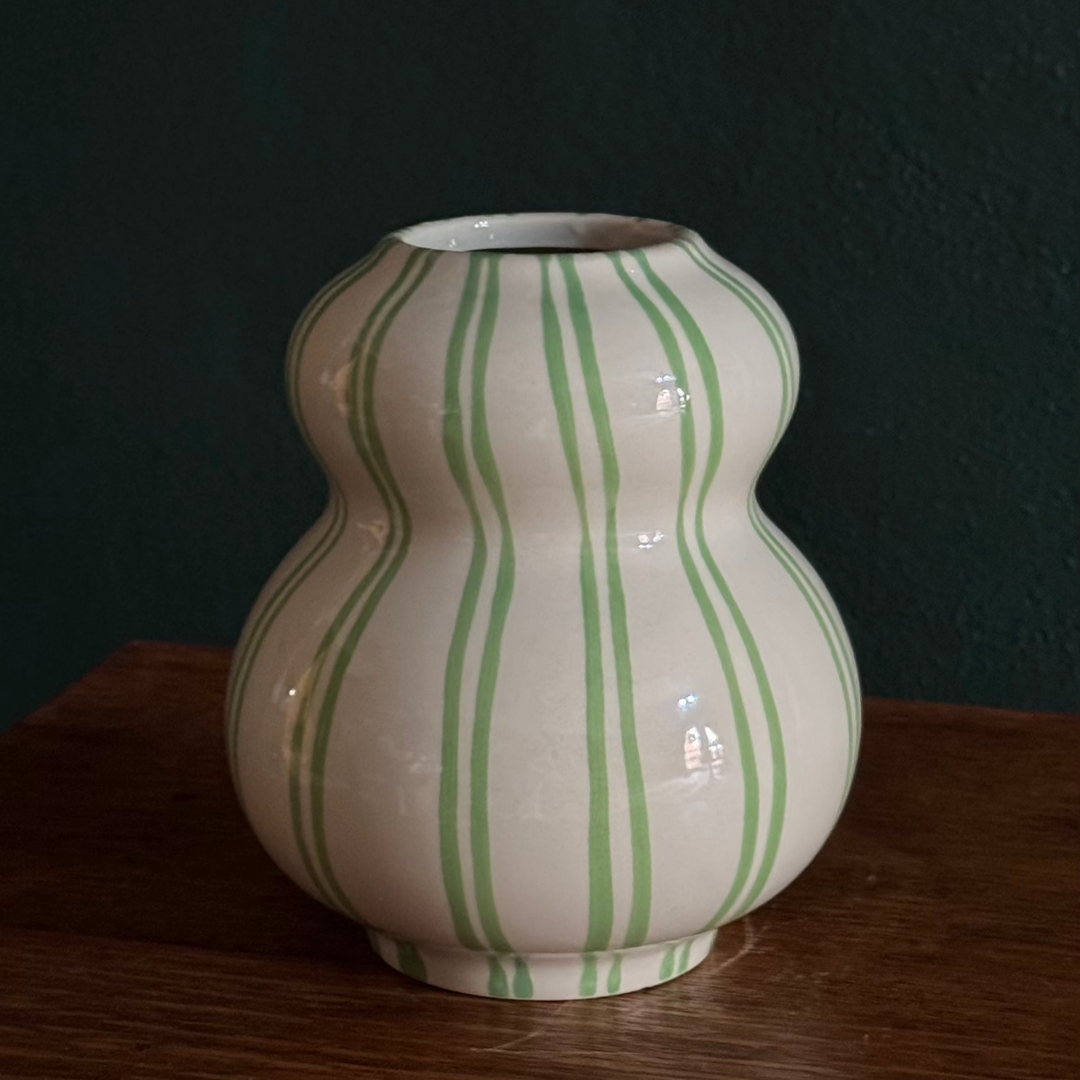 A off-white ceramic gourd-shaped vase with green stripe patterns.