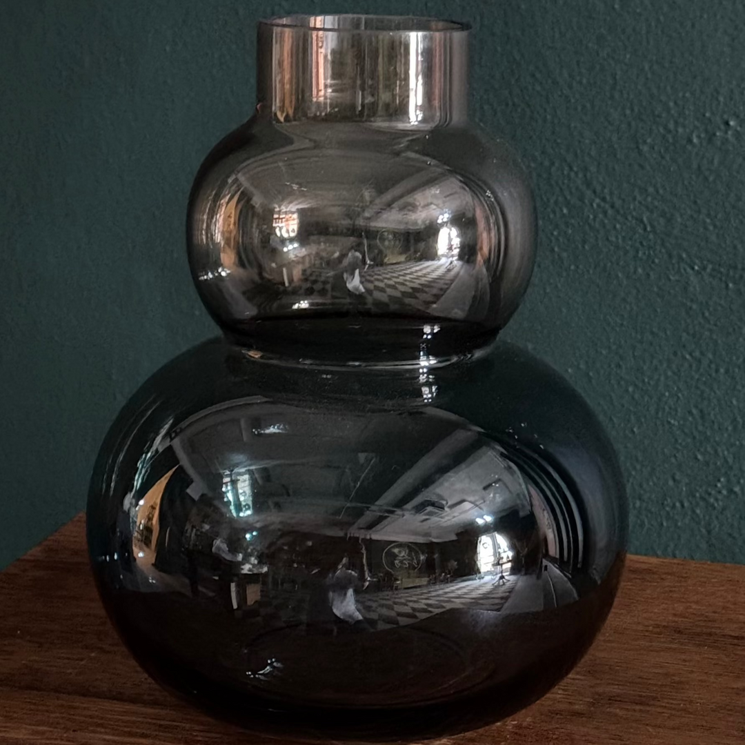 A two-toned bubble vase with stacked glass spheres in dusk-inspired colors of pink and blue, displayed against a dark background.