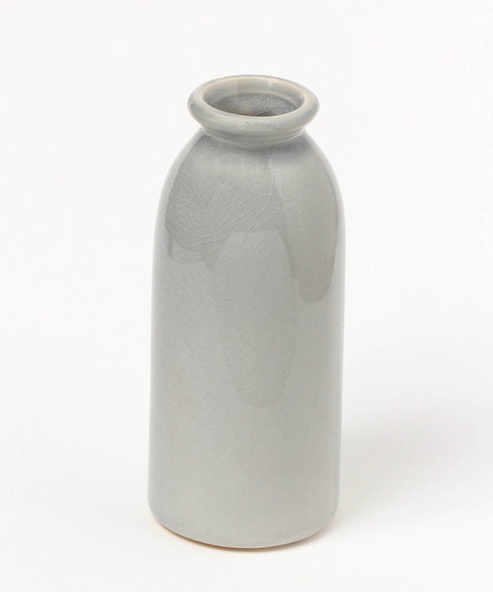 A gray ceramic flower vase designed to resemble a classic milk bottle with fine cracks on the surface.