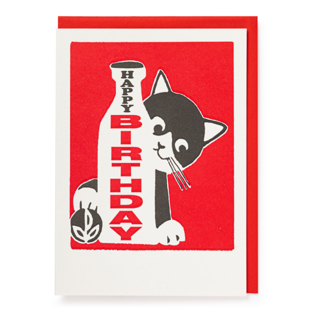 A greeting card with a whimsical illustration of a cat next to a birthday candle with 'Happy Birthday' text on it. The background is red, and the card has a white border.