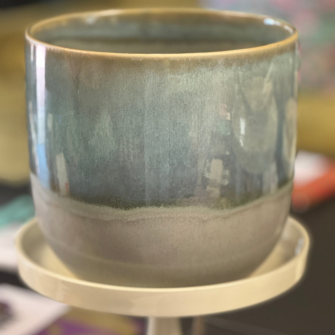 A ceramic planter with a green and blue color gradient, displayed on a white surface.