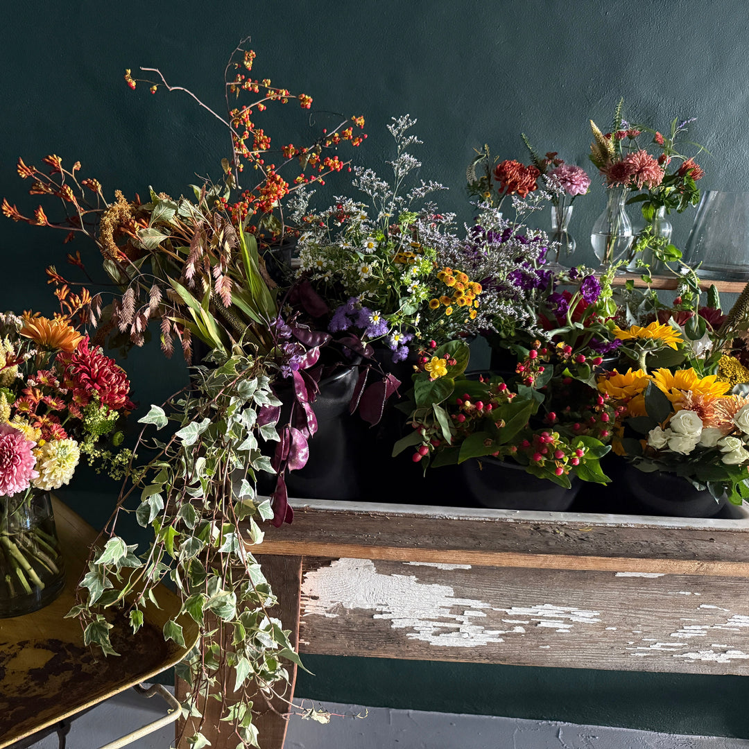 Bouquets of flowers on a wooden table against a dark background
