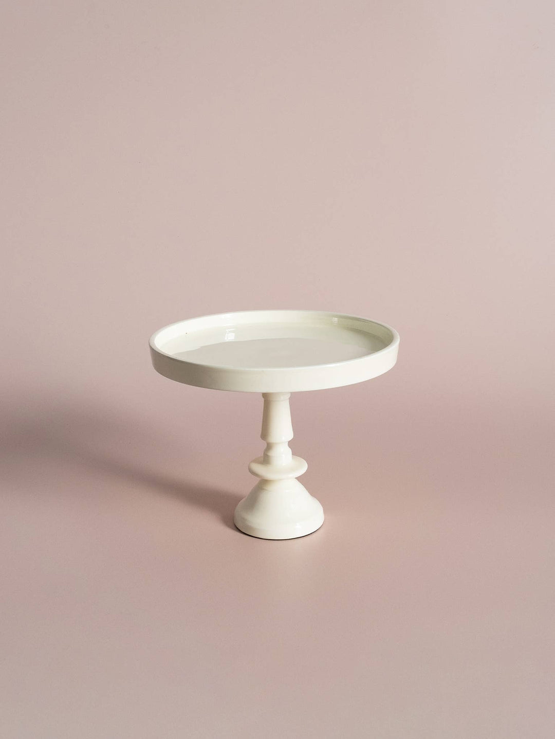 A small off white pedestal with a vintage-inspired design, featuring a single circular platform on top and a sturdy base.