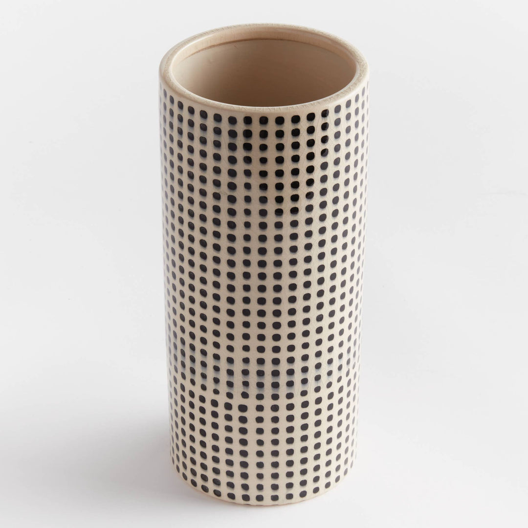 Cylindrical ceramic vase with black dot pattern on a white background