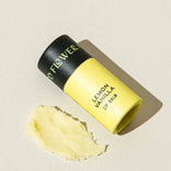 Lemon Vanilla lip balm with black and yellow packaging on a beige background