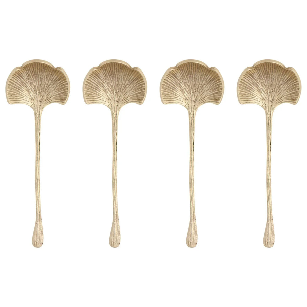 Four gold decorative spoons with leaf-like handles on a white background
