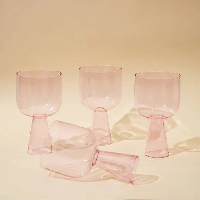 Set of pink glass goblets on a beige background