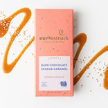 Moonstruck dark chocolate sesame caramel bar packaging on a white background with caramel drizzle.