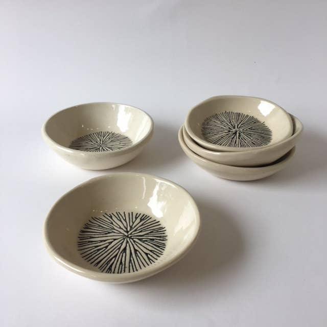 A set of three beige ceramic bowls with a geometric star pattern inside, displayed on a white background.