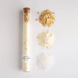 Spa-like bath salt product with natural ingredients on a light gray background
