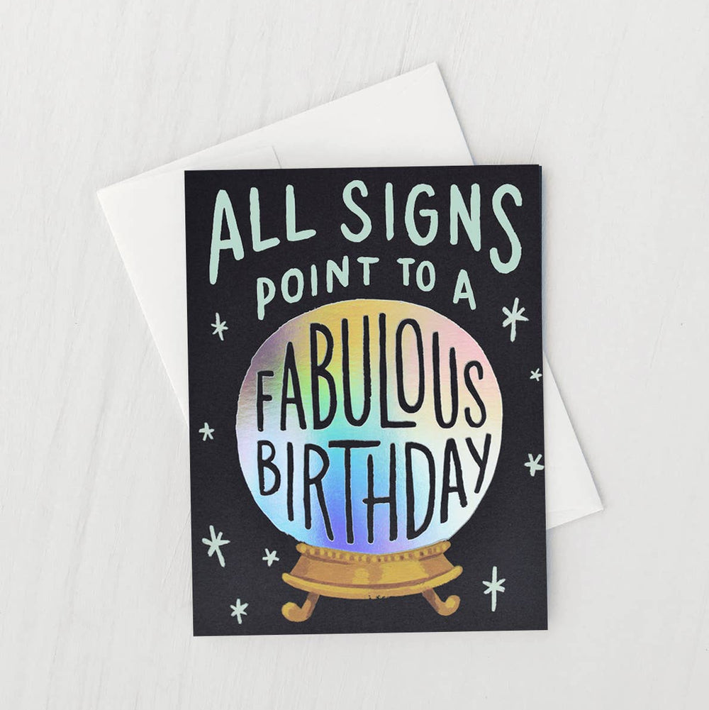 Greeting card with 'All signs point to a fabulous birthday' text and crystal ball illustration on a white background.