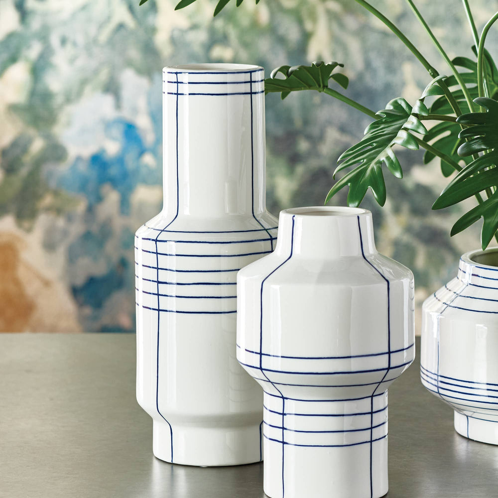 White vases with blue lines on a table with a blurred background