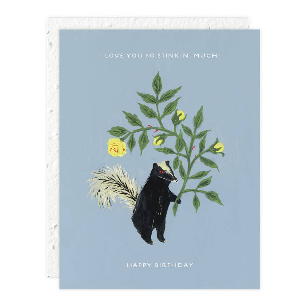 Greeting card with a skunk and floral design on a blue background