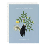 Greeting card with a skunk and floral design on a blue background
