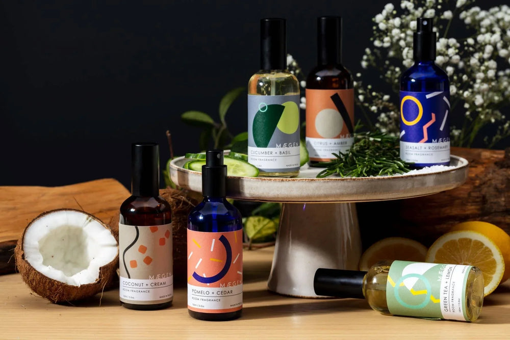 Assorted room fragrance sprays with natural ingredients like coconut, citrus, and herbs on display.