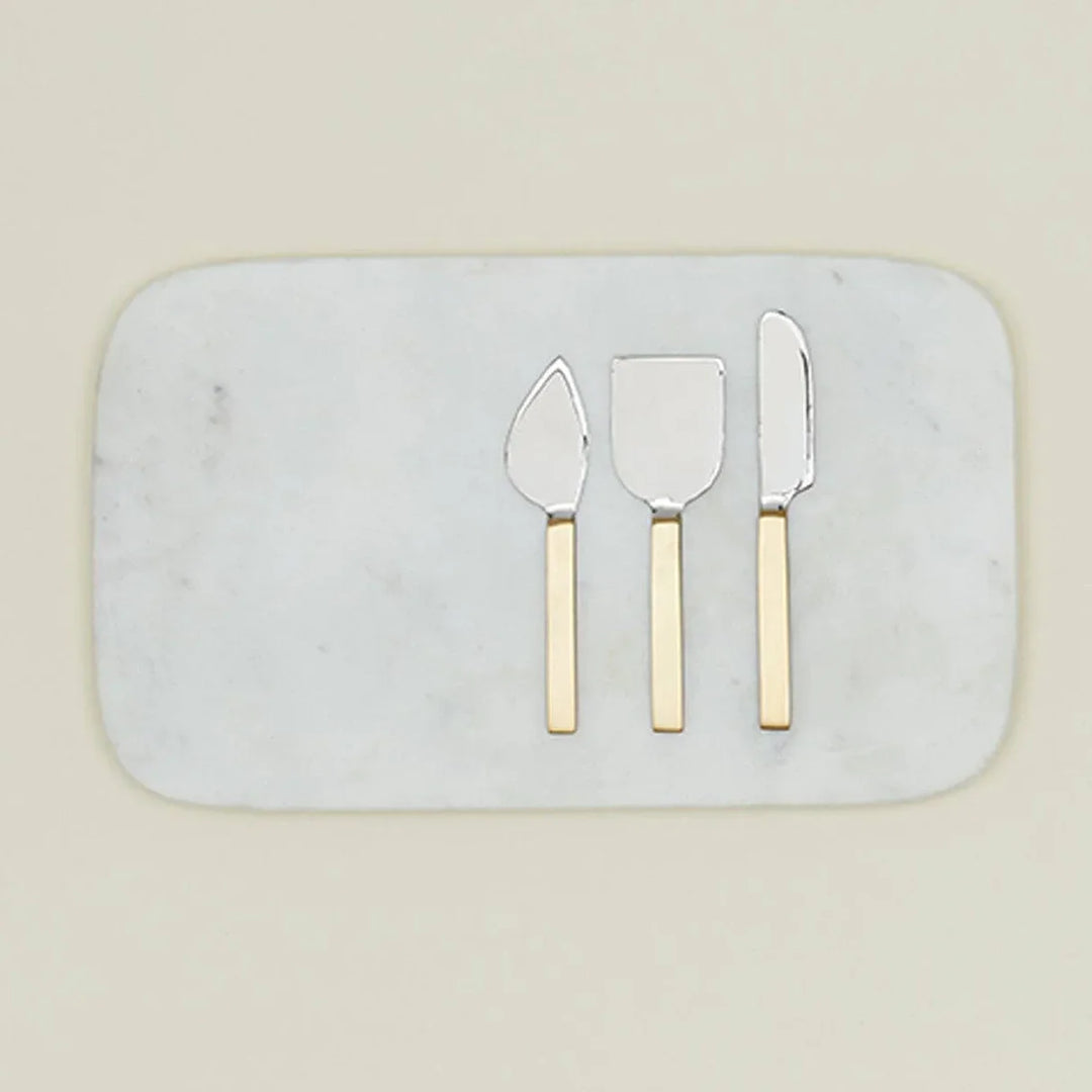 Elegant marble cheese board with gold-handled serving utensils for gourmet entertaining