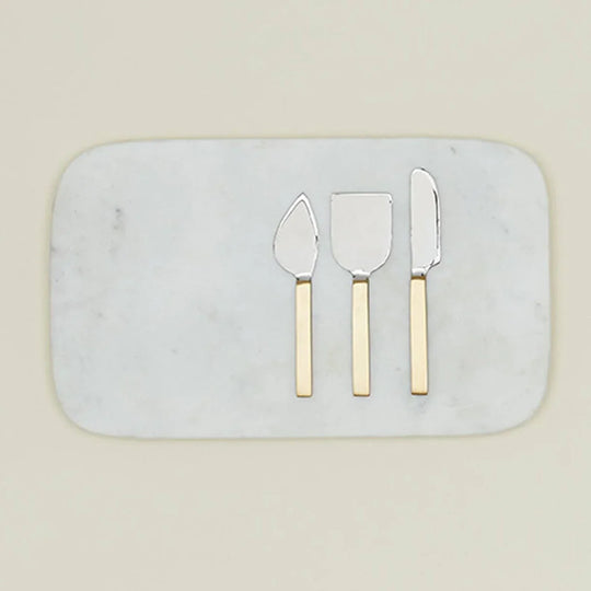Elegant marble cheese board with gold-handled serving utensils for gourmet entertaining