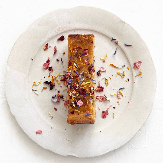 Rectangular dessert with edible flowers on a white plate