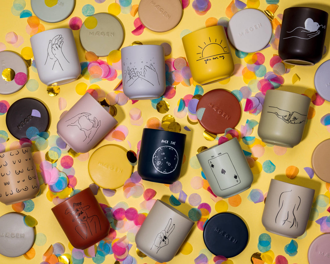 Collection of mugs with various designs on a yellow background with colorful confetti