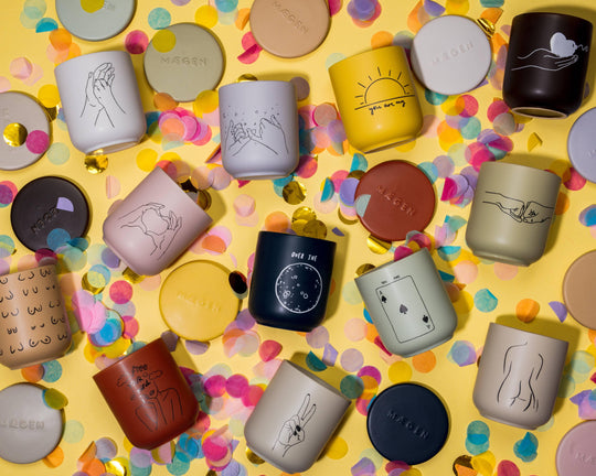 Collection of mugs with various designs on a yellow background with colorful confetti