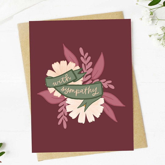 Greeting card with floral design and 'with sympathy' text on a maroon background