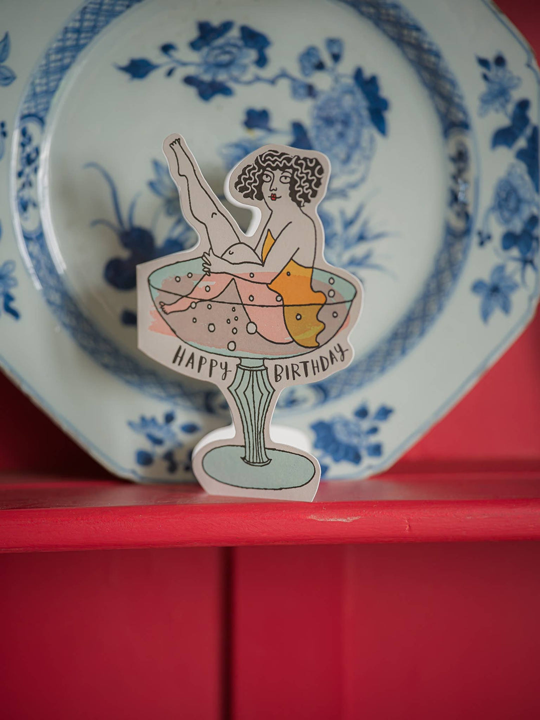 Sticker of a woman in a glass with 'Happy Birthday' text on a decorative plate.