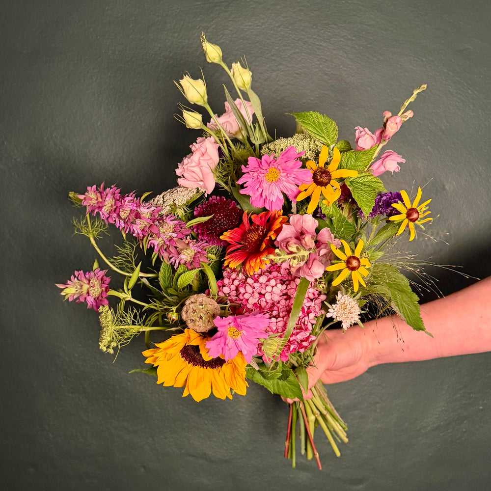 bouquet of wildflowers against a green wall