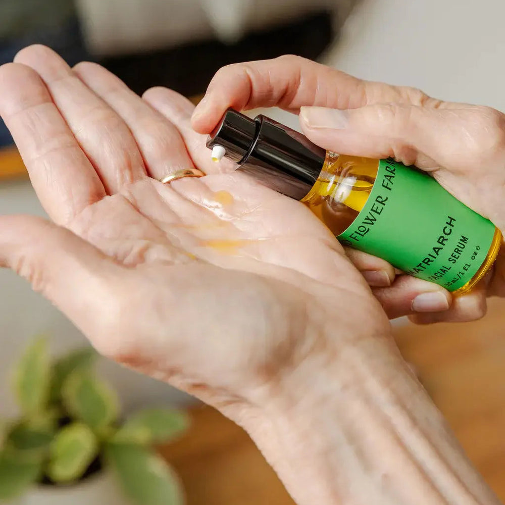 Person applying a product from a bottle labeled 'RIVER FARM' to their hand.