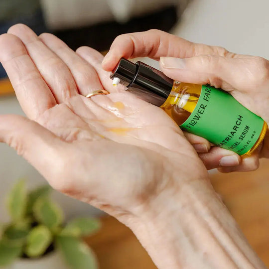 Person applying a product from a bottle labeled 'RIVER FARM' to their hand.