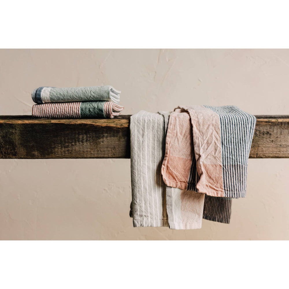 Stack of folded towels on a wooden surface against a beige wall