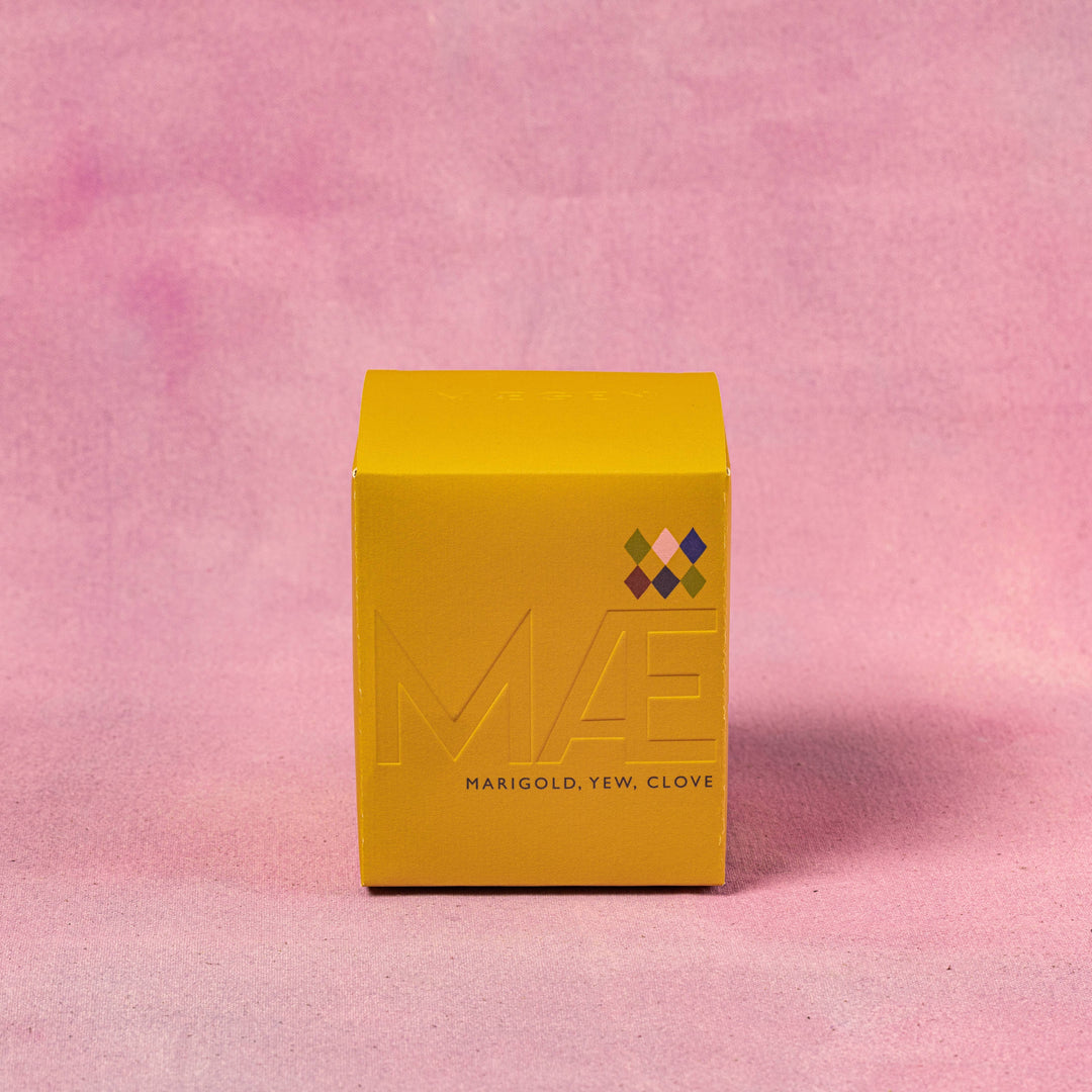 Yellow box with 'MAE' branding on a pink textured background