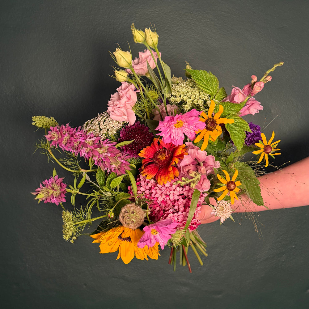 bouquet of wildflowers against a green wall