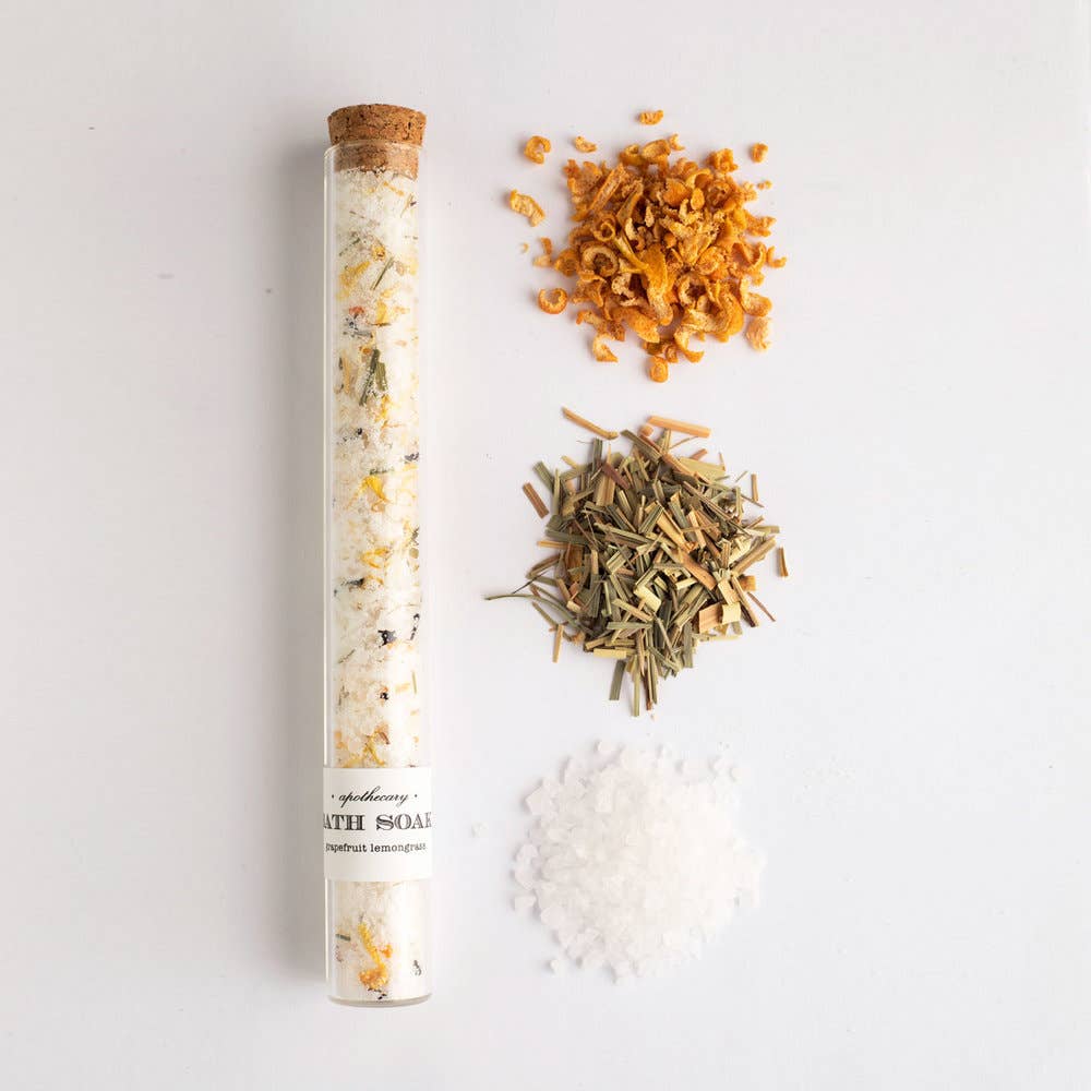 Tube of bath soap with dried herbs and sea salt on a light background