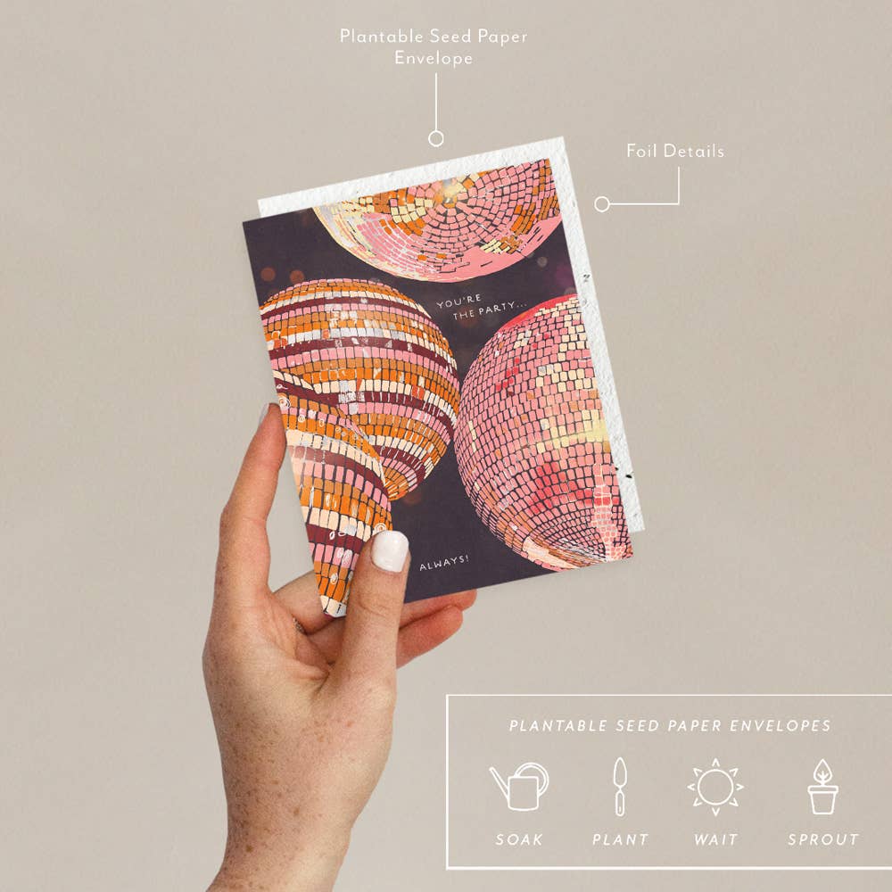 Hand holding a colorful card with plantable seed paper envelope features.