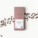 Moonstruck Dark Chocolate Espresso bar with scattered coffee beans on a white background