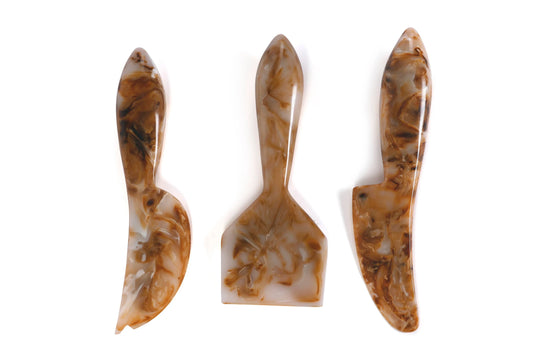 Three marbled brown and beige ceramic tools on a white background
