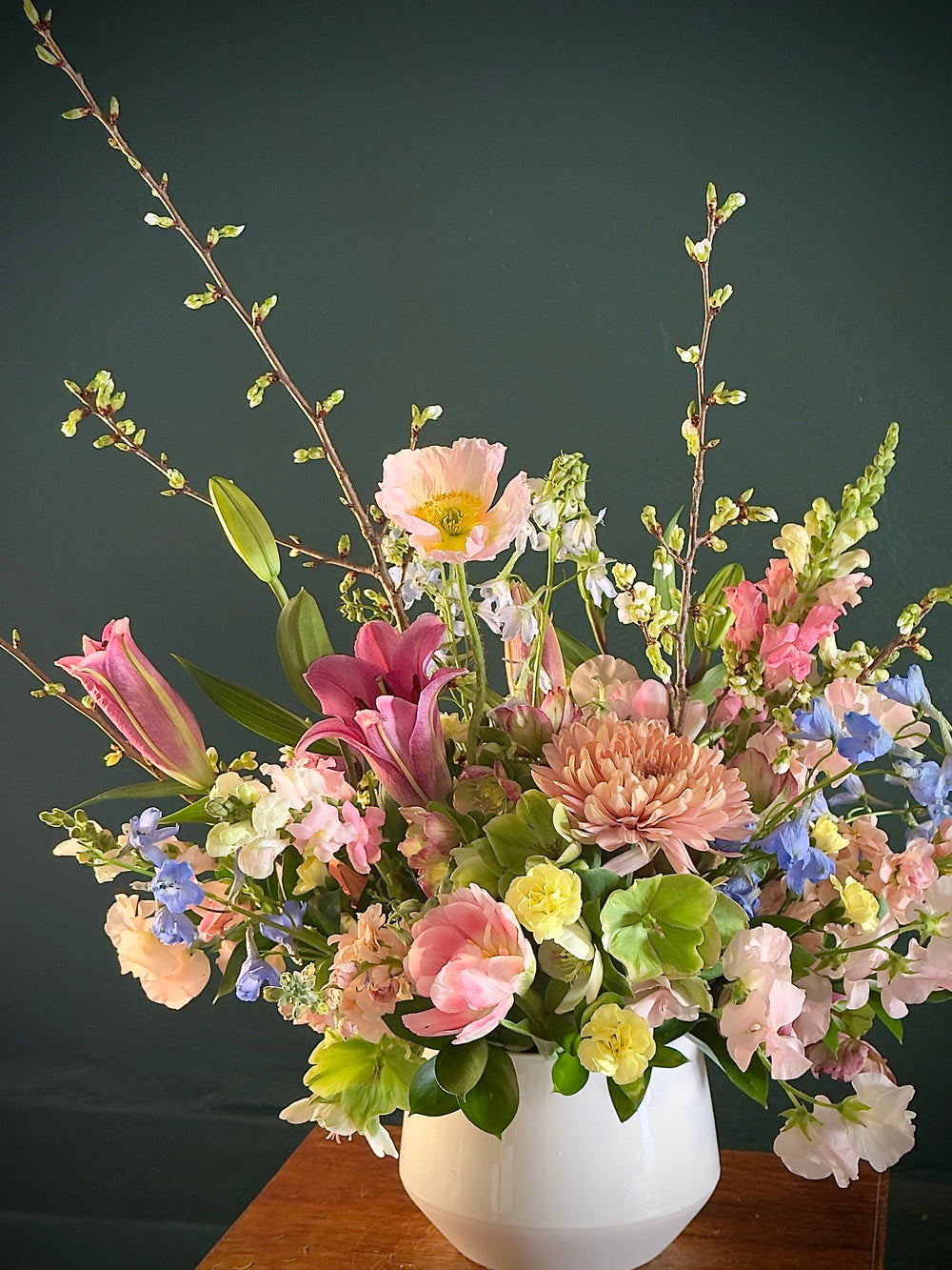 Colorful flower arrangement in a white vase on a dark background