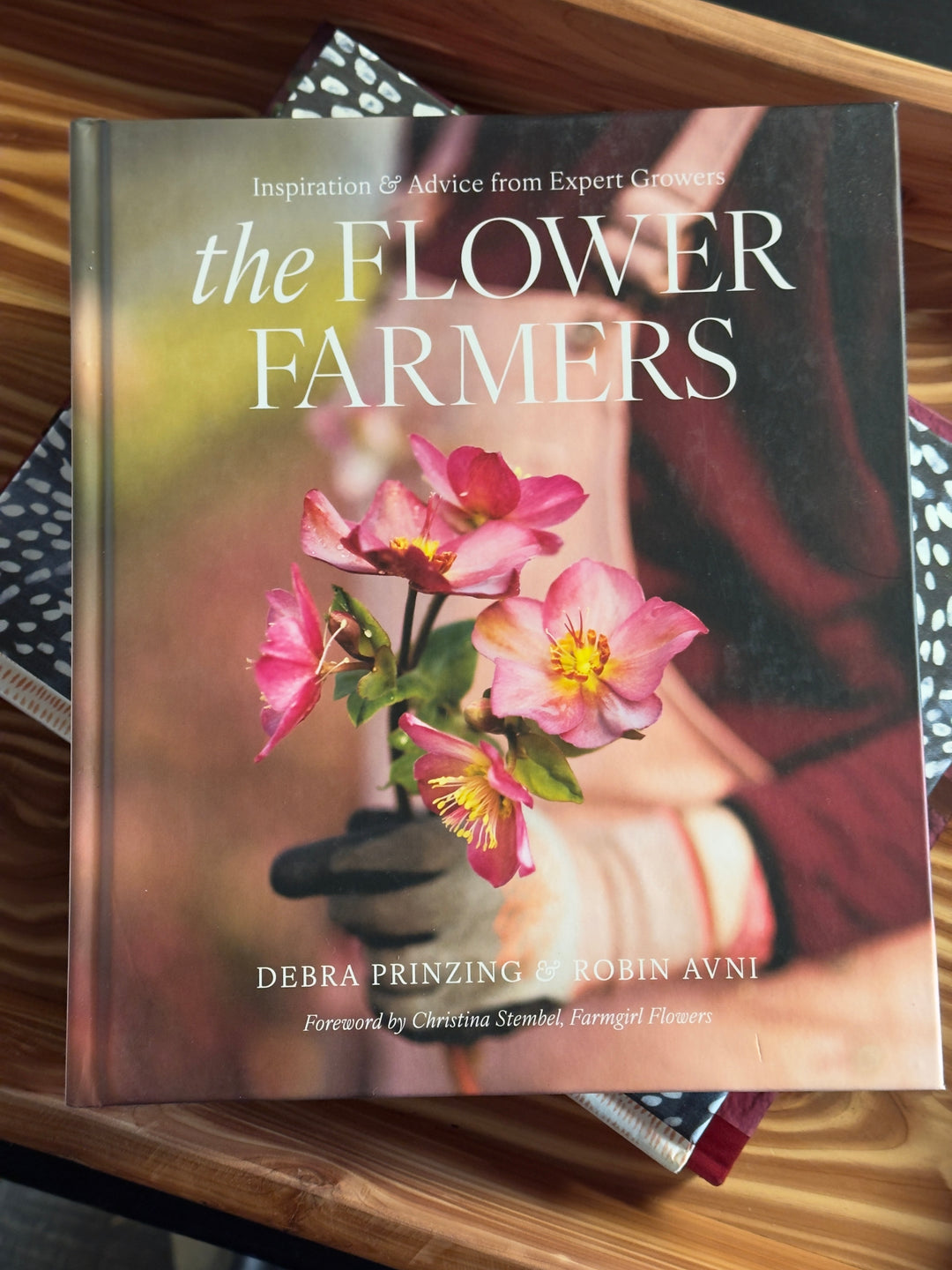 Book titled 'The Flower Farmers' on a wooden surface