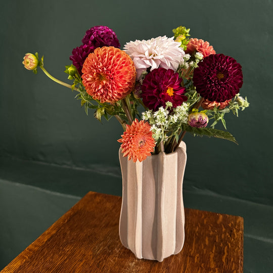 Bouquet of flowers with a decorative vase against a dark background
