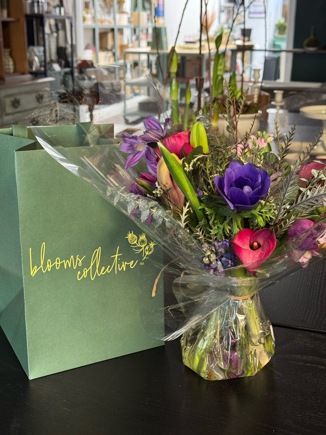 Bouquet of flowers with a green card on a reflective surface