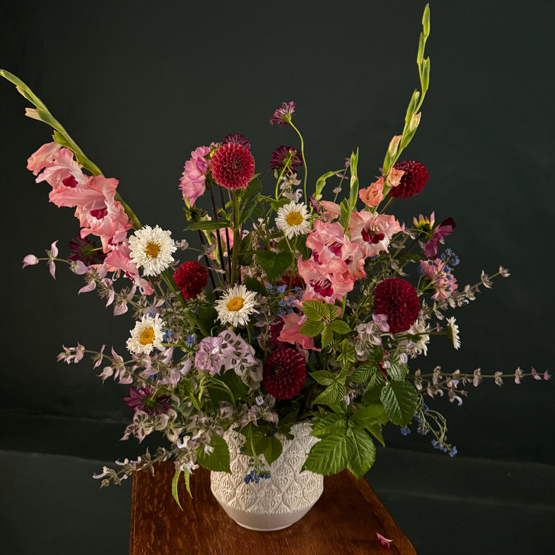 Floral arrangement in a white vase on a dark background