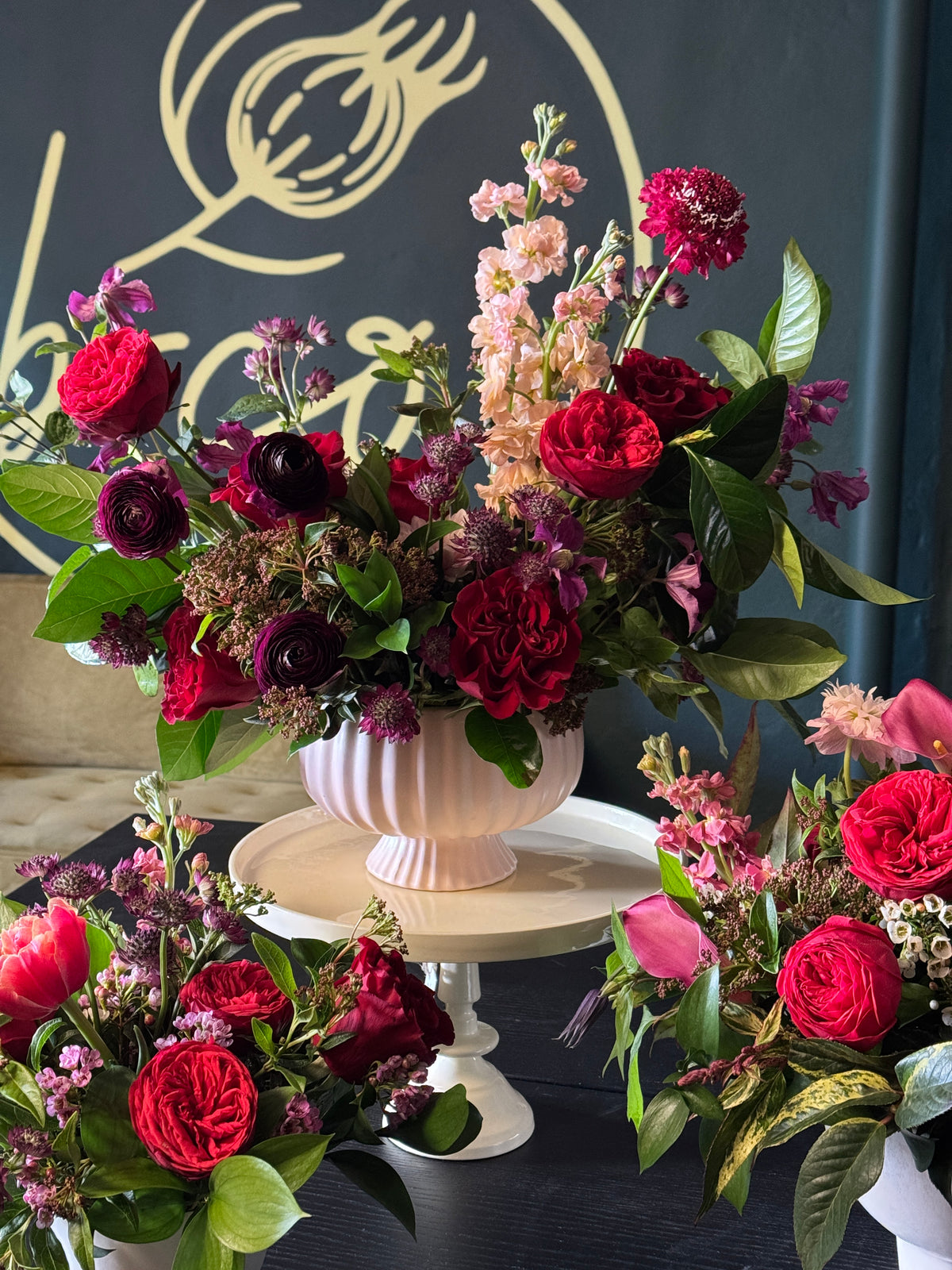Bouquets of red and pink flowers with green leaves on a dark background