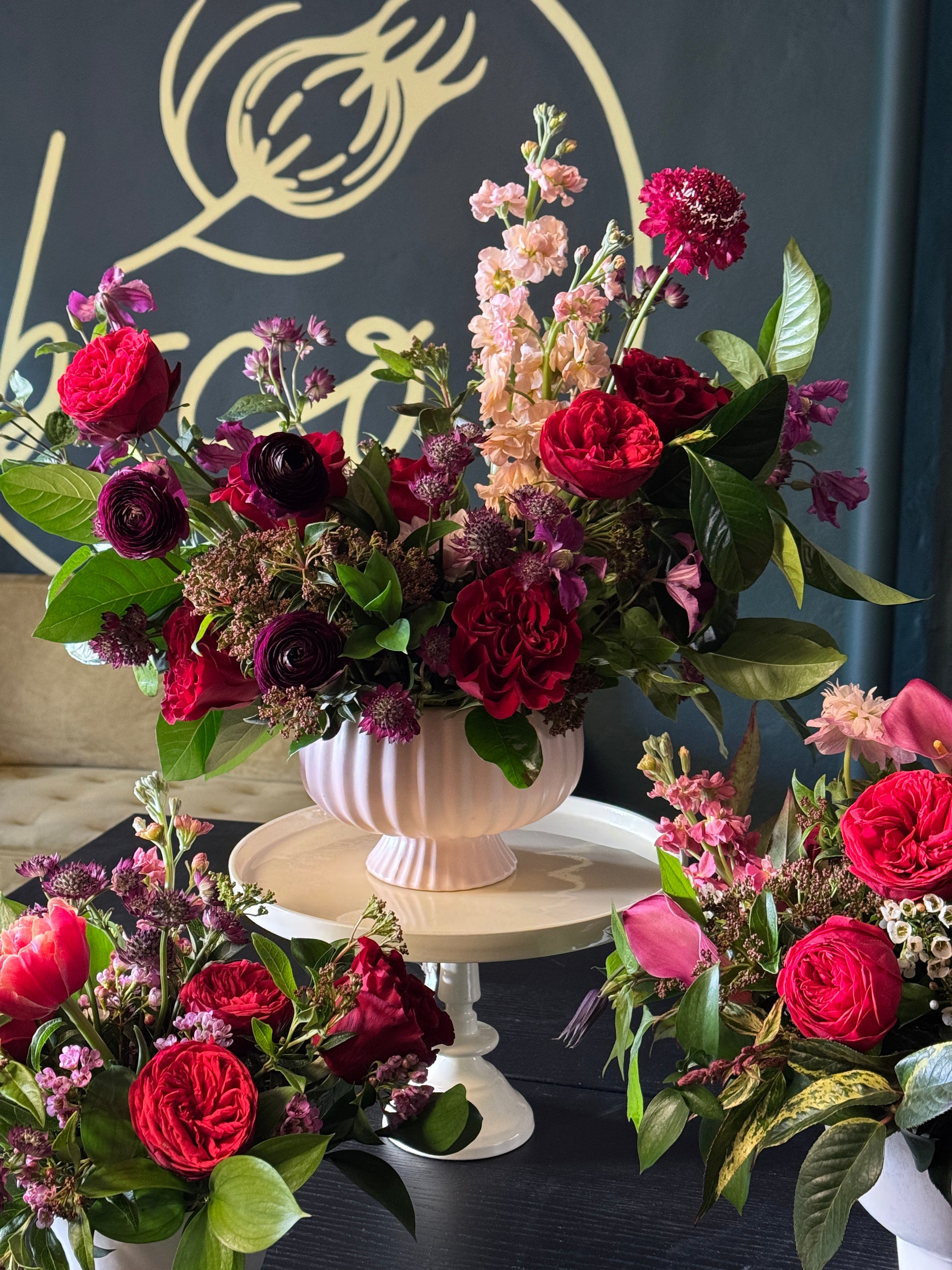 Bouquets of red and pink flowers with green leaves on a dark background