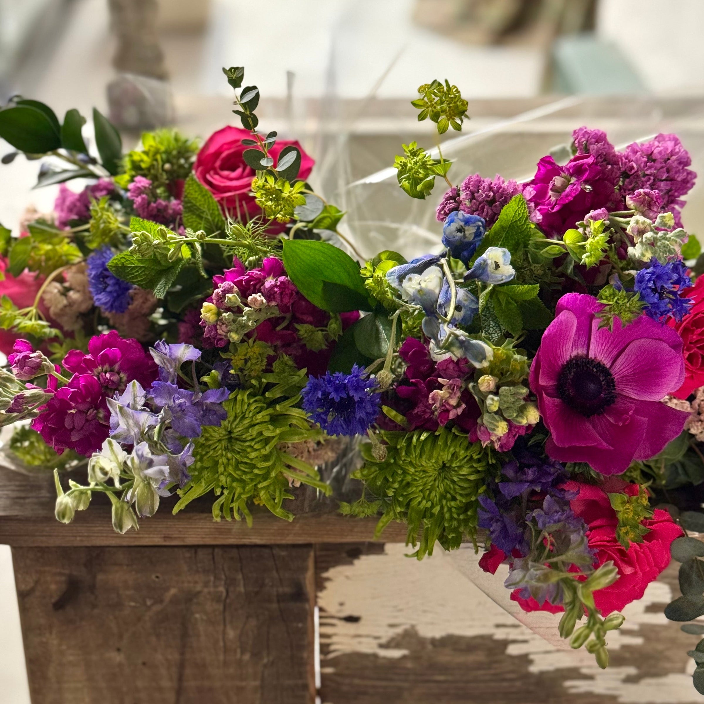Bouquet of colorful flowers on a wooden table with a blurred background