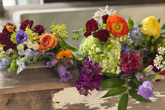 Colorful flower arrangement on a wooden surface with a blurred background