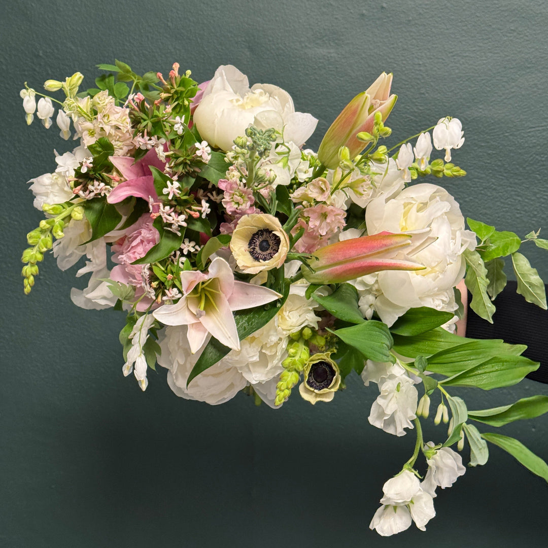 Bouquet of flowers with white, pink, and green colors on a dark background