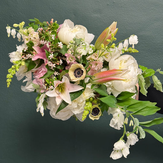 Bouquet of flowers with white, pink, and green colors on a dark background
