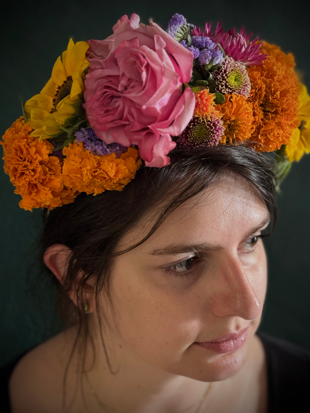 Woman wearing a colorful flower crown with a dark background