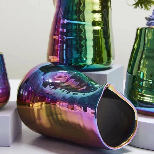 Iridescent glass vases with flowers on a white background