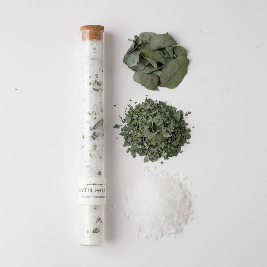 Bath salt with eucalyptus leaves and salt on a white background